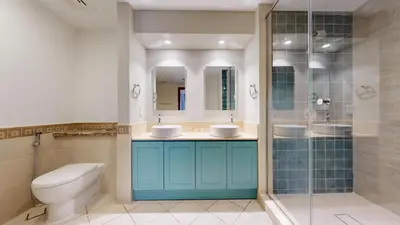 a bathroom with a toilet and two sinks and a shower at Golden Mile - Serene Two Bedroom on the Palm in Dubai