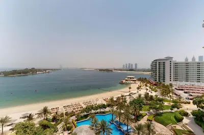a view of a beach and the ocean with buildings at Al Dabas - One Bed with Beach Access and Sea View in Dubai