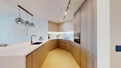 a kitchen with white counters and wooden cabinets at Al Dabas - One Bed with Beach Access and Sea View in Dubai