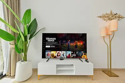 a living room with a tv on a white cabinet at Golden Stays - Binghatti Crescent I Cozy 1BR Retreat I Pool & Gym I JVC Dubai in Dubai