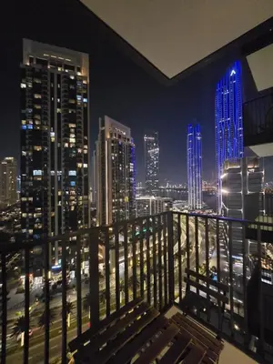 a balcony with a view of a city at night at Creek crescent high floor in Dubai