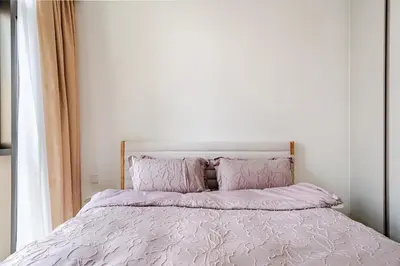 a bed with pink blankets and pillows in a bedroom at Creek crescent high floor in Dubai