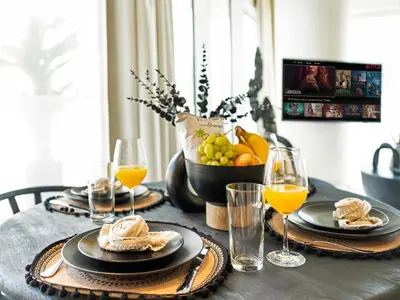 a table with plates of food and glasses of orange juice at Cozy Luxury One Bedroom Sea View on Private Beach and Infinity Pool in Dubai