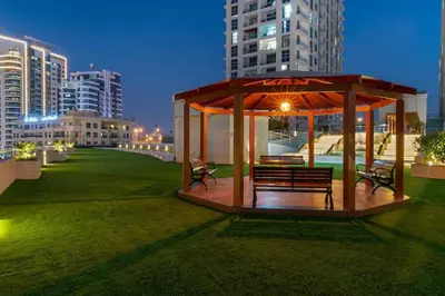a gazebo with benches in a city at night at Lux 3 BR Sea View Condo with Pool & Sauna In Marina in Dubai