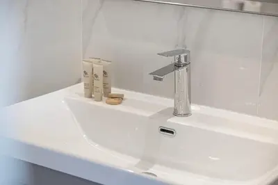 a white bathroom sink with a faucet on it at Lux 3 BR Sea View Condo with Pool & Sauna In Marina in Dubai