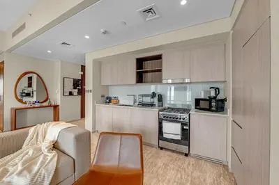 a kitchen with a stove and a couch in a room at Guest Favorite - Premium & Modern 2BR Stay at Dubai Creek Harbour in Dubai