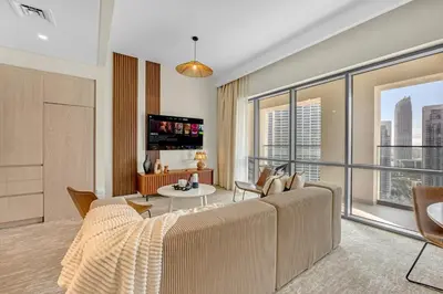 a living room with a couch and a large window at Guest Favorite - Premium & Modern 2BR Stay at Dubai Creek Harbour in Dubai