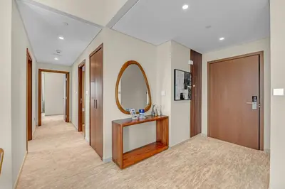 a hallway with a mirror and a wooden door at Guest Favorite - Elegant & Stylish 2BR Stay at Vida Creek Harbour in Dubai