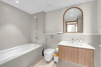 a bathroom with a sink and a toilet and a bath tub at Guest Favorite - Elegant & Stylish 2BR Stay at Vida Creek Harbour in Dubai