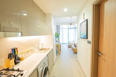 a white kitchen with a sink and a stove at Chic Urban Studio in Dubai in Dubai