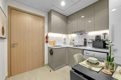 a kitchen with gray cabinets and a wooden door at Chic Urban Studio in Dubai in Dubai