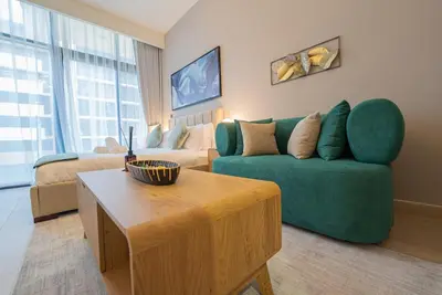 a living room with a green couch and a coffee table at Chic Urban Studio in Dubai in Dubai