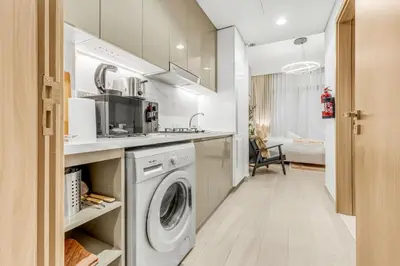 a kitchen with a washer and dryer in a room at Fully Furnished Studio with Scenic Views in Dubai