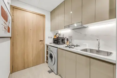 a kitchen with a sink and a washing machine at Fully Furnished Studio with Scenic Views in Dubai