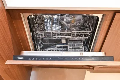 a dishwasher in a cabinet with its door open at Beach Serenity, Modern 1BR in Dubai, Palace Beach Residences, Emaar Beachfront in Dubai