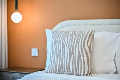 a bed with a striped pillow and a lamp at Beach Serenity, Modern 1BR in Dubai, Palace Beach Residences, Emaar Beachfront in Dubai