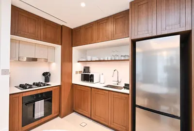 a kitchen with wooden cabinets and a sink at Beach Serenity, Modern 1BR in Dubai, Palace Beach Residences, Emaar Beachfront in Dubai