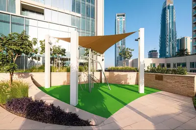 a playground in front of a building with tall buildings at Vogue Downtown Forte near Dubai Mall and Burj Khalifa, Two-Bedroom Apartment with Balcony and City View, full access to all amenities in Dubai