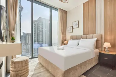 a bedroom with a large white bed and a large window at STAY BY LATINEM Luxury 1BR and Study Holiday Home CC 2808 Near Downtown in Dubai