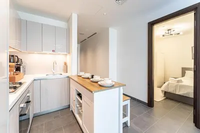 a kitchen with a counter and a sink and a bed at HAVN - 2 Bedroom at The Crest, Dubai Skyline Views in Dubai