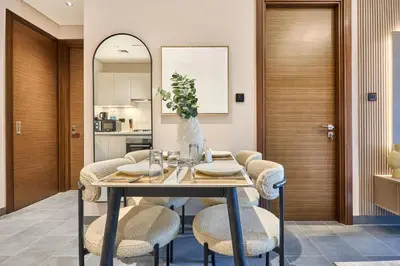 a dining room with a table and chairs at STAY BY LATINEM Luxury 1BR Holiday Home CB 0905 Near Burj Khalifa in Dubai