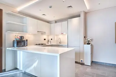 a kitchen with white cabinets and a large island at STAY BY LATINEM Luxury 2BR Holiday Home CC 1014 Near Burj Khalifa in Dubai