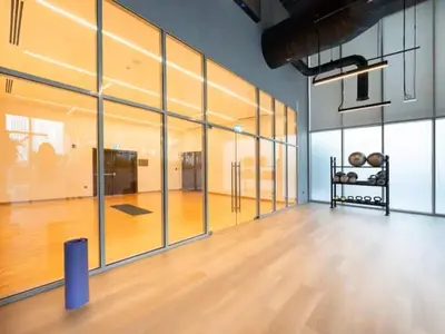 a large room with a wooden floor and glass walls at Vogue Downtown Forte near Dubai Mall and Burj Khalifa, Two-Bedroom Apartment with Balcony and City View, full access to all amenities in Dubai