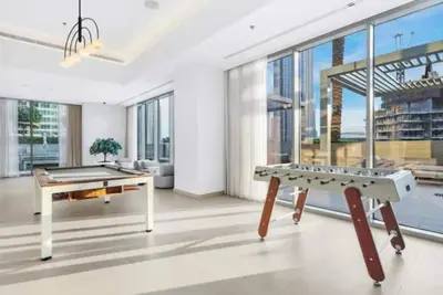 a living room with a ping pong table and large windows at Vogue Downtown Forte near Dubai Mall and Burj Khalifa, Two-Bedroom Apartment with Balcony and City View, full access to all amenities in Dubai