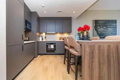 a kitchen with a counter and a bar with stools at NEU Sea and Burj View Port de La Mer in Dubai