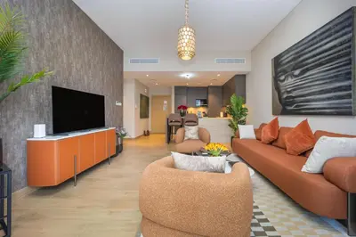 a living room with a couch and a flat screen tv at NEU Sea and Burj View Port de La Mer in Dubai