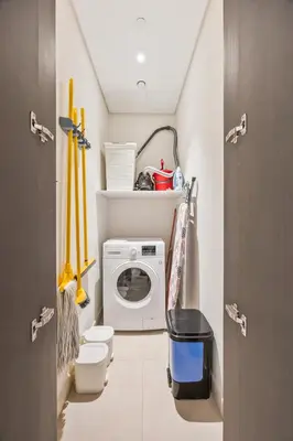 a small bathroom with a washing machine in a room at 2BR Apt Direct Dubai Mall Access Burj View in Dubai