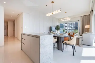 an open kitchen and dining room with a table and chairs at Chic 2 bedroom w Sunset and Palm Jumeirah Views in Dubai