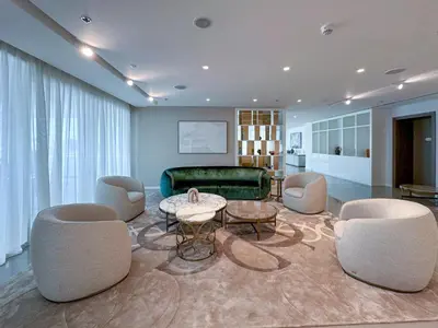 a living room with chairs and a couch and a table at Chic 2 bedroom w Sunset and Palm Jumeirah Views in Dubai