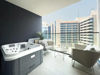 a hot tub in a room with a large window at Modern Studio with Private Jacuzzi in Dubai