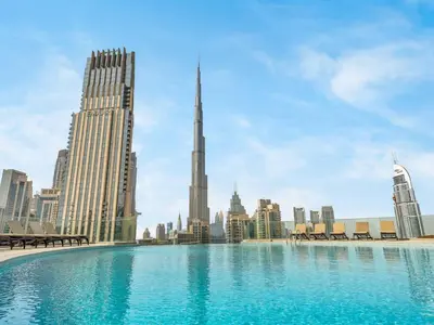 a large swimming pool with a city skyline in the background at Downtown Charm Burj View 1BR in Dubai