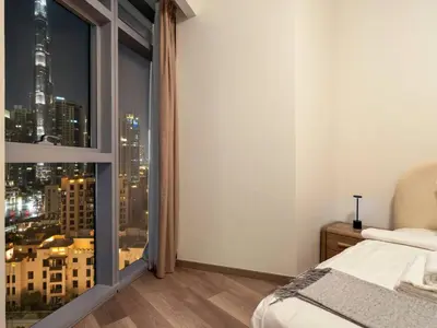 a bedroom with a large window with a city view at Downtown Charm Burj View 1BR in Dubai