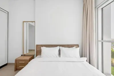 a bedroom with a white bed and a mirror at Dubai Hills 2BR Collective Tower in Dubai