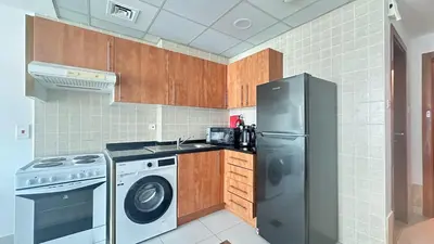 a kitchen with a refrigerator and a washing machine at Marine View Tower aparthotel in Dubai
