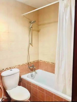 a bathroom with a toilet and a tub with a shower at Marine View Tower aparthotel in Dubai