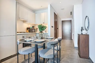 a kitchen and dining room with a table and chairs at STAY BY LATINEM Luxury 1BR Holiday Home CB 2701 Near Burj Khalifa in Dubai