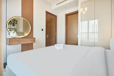 a bedroom with a white bed and a mirror at STAY BY LATINEM Luxury 1BR Holiday Home CB 2701 Near Burj Khalifa in Dubai