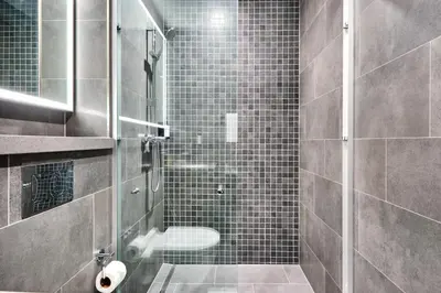 a bathroom with a glass shower with a toilet at STAY BY LATINEM Luxury 1BR Holiday Home CB 2701 Near Burj Khalifa in Dubai