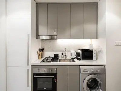 a kitchen with a sink and a washing machine at Livin' Holidays - Studio - Azizi Near Downtown in Dubai