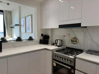 a kitchen with white cabinets and a stove top oven at Stylish One Bedroom Apartment at Binghatti Crest, JVC Dubai By al sarya Holiday Homes in Dubai