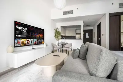 a living room with a couch and a tv at StayShort - Dubai Marina sleeps 4 with Water Views! in Dubai