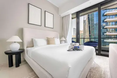 a bedroom with a white bed and a large window at StayShort - Dubai Marina sleeps 4 with Water Views! in Dubai