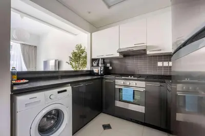 a kitchen with a washing machine and a washer at StayShort - Dubai Marina sleeps 4 with Water Views! in Dubai