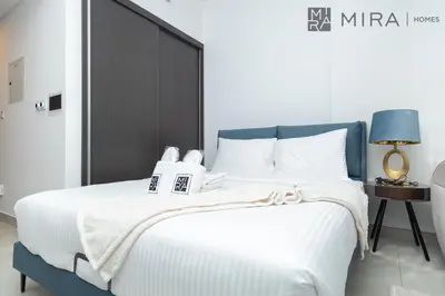 a bedroom with a white bed with a black headboard at Mira Holiday Homes - Paragon by IGO Studio Where Style Meets Comfort in Dubai
