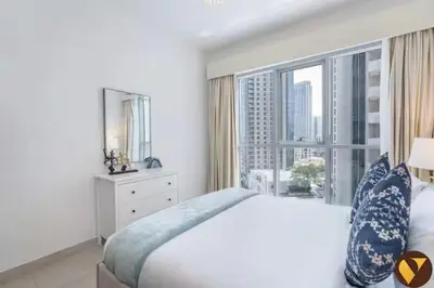 a bedroom with a bed and a large window at Vogue Downtown Boulevard Central near Burj Khalifa and Dubai Mall, Two Bedroom Apartment with Balcony and Burj Khalifa View, Access to all Amenities in Dubai