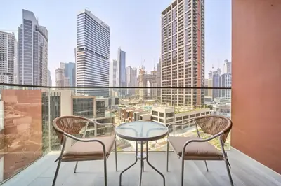 a table and two chairs on a balcony with a city view at FAM Living Dubai Escape Sleek Studio at Peninsula Five in Dubai